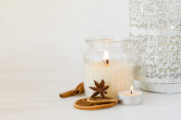 Rustic zero waste natural christmas decor. Candle in glass jar, spices, dry orange, green fir tree banches. Decoration for holiday dinner table. Happy new year. Holiday atmospere, festive mood