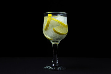 Refreshing cocktail with ice and lemon on a black background. Non-alcoholic cocktail.
