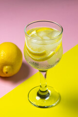 Refreshing cocktail with ice and lemon on a colored background. Non-alcoholic cocktail.