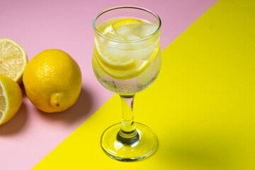 Refreshing cocktail with ice and lemon on a colored background. Non-alcoholic cocktail.