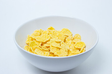 Plate with cornflakes on a white background. Healthy and tasty breakfast.