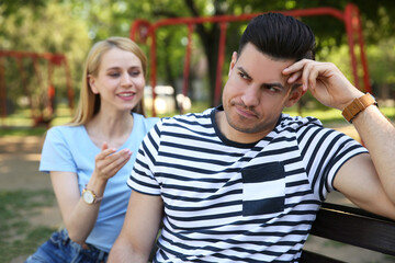 Obraz premium Displeased man ignoring overtalkative young woman during first date in park