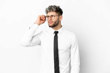 Business caucasian man isolated on white background having doubts and with confuse face expression