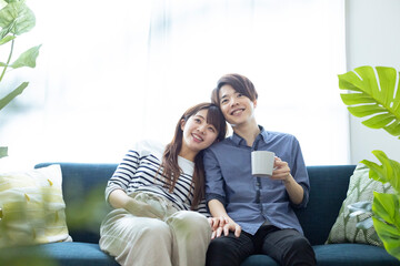 Obraz premium リビングでくつろぐ仲の良い日本人の男女