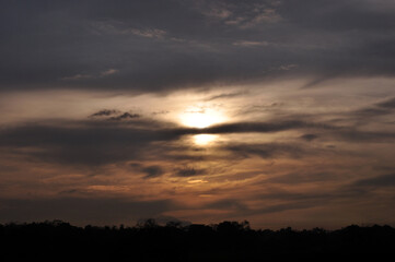 Fototapeta premium The sunset is very beautiful when the sky is dark or cloudy, indicating that it will soon rain in the tropics in the rice field areas.