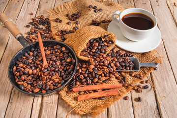 Coffee cup and beans on old woodden table
