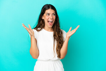 Young caucasian woman isolated on blue background with surprise facial expression