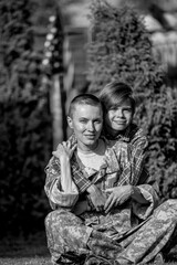 Happy reunion of female mother soldier with family son outdoors	