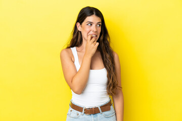Young caucasian woman isolated on yellow background nervous and scared