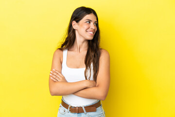 Obraz premium Young caucasian woman isolated on yellow background with arms crossed and happy