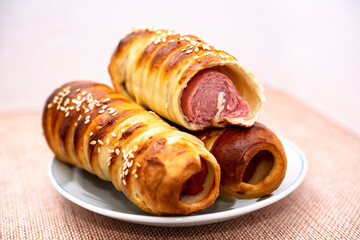 bitten sausage in a dough on a plate