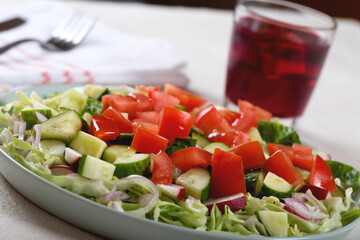 Dinner table with vegetable salad and red wine in a glass