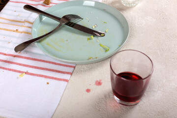 Empty dirty plate with cutlery after eaten food in restaurant on table