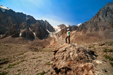 Photo of a tourist girl in the Altai Mountains. In the background is the Bolshoy Aktru Glacier.