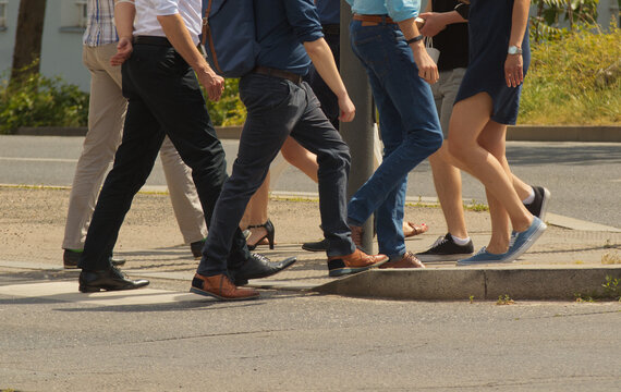 A crowd of pedestrians crossing street in the city, people walking in the street