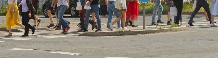 A crowd of pedestrians crossing street in the city, people walking in the street