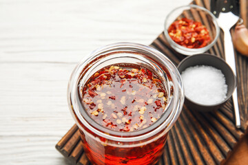 Composition with jar of hot honey on light wooden background