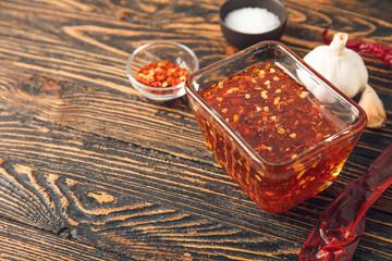 Bowl with hot honey and ingredients on wooden background