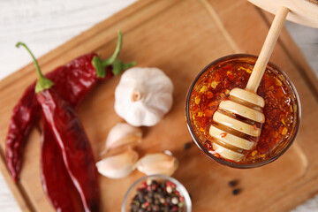 Board with hot honey and ingredients on table