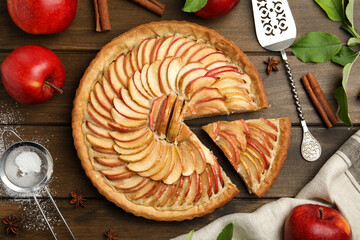 Delicious apple pie and ingredients on wooden table, flat lay
