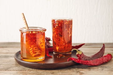 Fotobehang Chili Pepers Composition with hot honey and dry chili peppers on wooden table  © Pixel-Shot