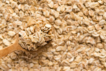 Oatmeal and multi-grain flakes. Top view. Oats in a wooden spoon.