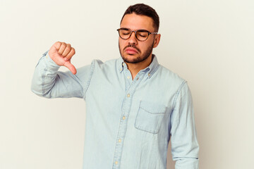 Young caucasian man isolated on white background showing a dislike gesture, thumbs down....