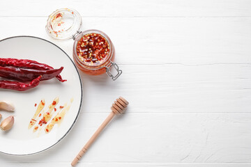 Composition with hot honey and ingredients on light wooden background