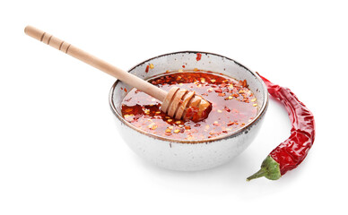 Bowl of hot honey and dry chili pepper on white background