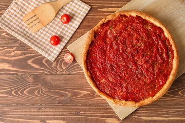 Board with tasty Chicago-style pizza on wooden background