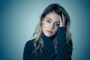 Fototapeta premium Portrait of young attractive caucasian woman suffering from depression, stress and anxiety. Sad and lonely woman crying, feeling depressed, distressed, worried and overwhelmed. Mental Health care.