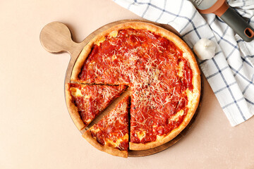 Board with tasty Chicago-style pizza on color background
