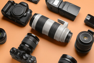 Modern photographer's equipment on color background