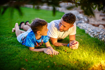 Fototapeta premium Father with his son lying down in the garden