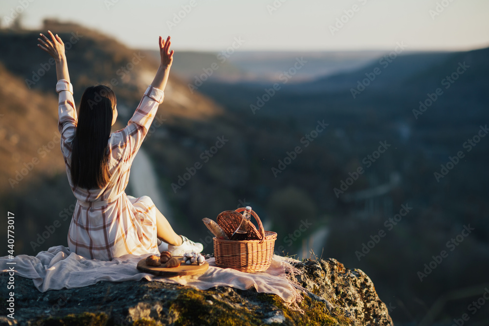 Wall mural Young woman enjoying nature and picnic with the hands up.