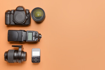 Modern photographer's equipment on color background