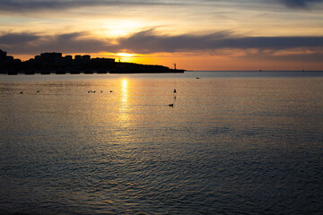 Naklejka premium City on the sea at sunset
