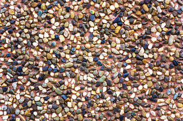 Texture of a brown ceramic stones. Ridge brown background of a facade. Ceramic surface.  Texture from small colored darkly pebble. Mosaic flooring, colored  stones.