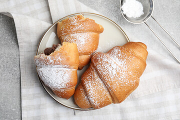 Flat lay composition with tasty croissants and sugar powder on light grey table