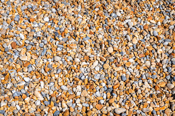 Looking straight down son Pebbles on a beach in the sun