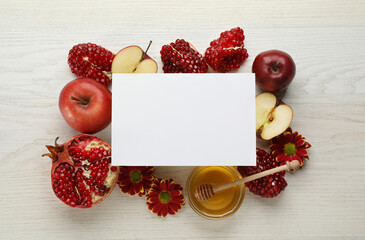 Flat lay composition with Rosh Hashanah holiday attributes and card on white wooden table. Space...