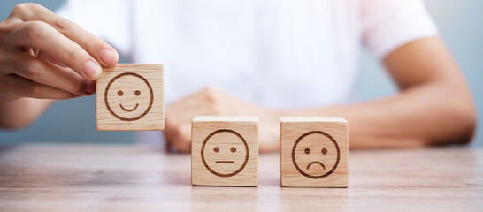 Man hand holding emotion face block. Customer choose Emoticon for user reviews. Service rating,...