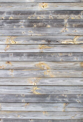 Fototapeta premium Wooden background made of old boards. The texture of an old rustic wooden fence made of flat processed boards. Wooden fence made of old boards with the inclusion of Knots. Background design