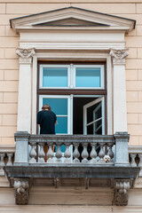 Fototapeta na wymiar Man from behind on the balcony while smoking a cigarette