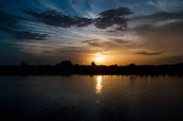 The sun is going to set beautifully on the river.