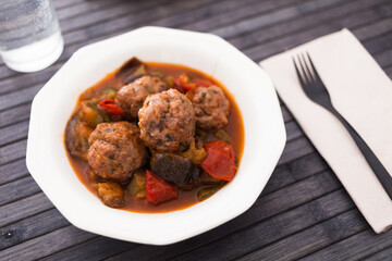 baked meatballs with stewed eggplant, zucchini, green peppers and tomatoes in bowl