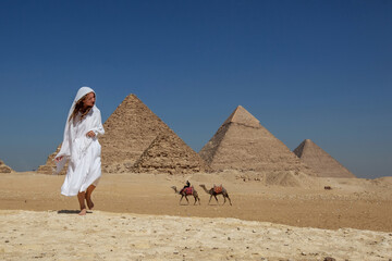 Beautiful woman near the ancient pyramids of Egypt