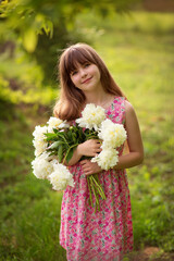 Photo of a young girl with a bouquet of white peonies.