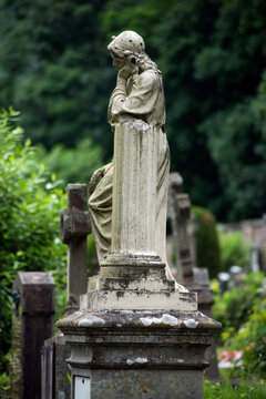 View of the virgin mary statue on tomb in a cemetery