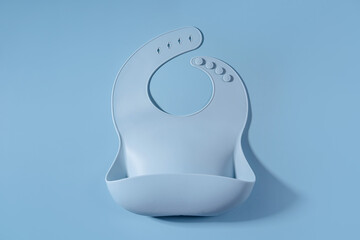 Blue silicone baby bib. First baby accessories for dinner. Top view, flat lay